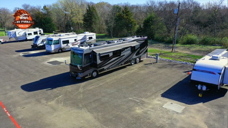 Motorhome and travel trailers parked on paved back-in sites at Dallas Melissa RV Park